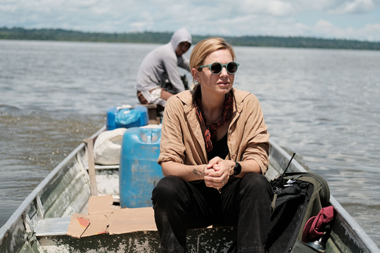 Mariana van Zeller me zonnebril in een klein bootje op een rivier.