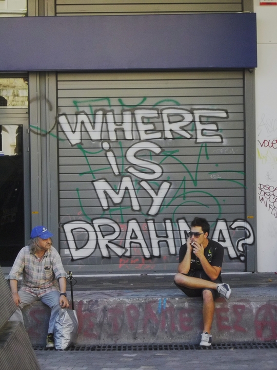 Deux hommes devant un tag "Where is my drahma" dans le quartier de Monastiraki, Athènes. (Photo: Pierre Jassogne, août 2009)