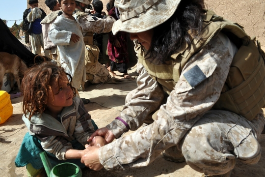 Militairen van de NATO verlenen medische verzorging aan Afghaanse kinderen. 