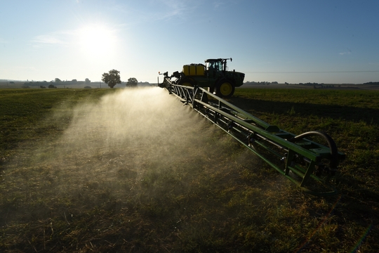 Een landbouwvoertuig besproeit een veld met glyfosaat.
