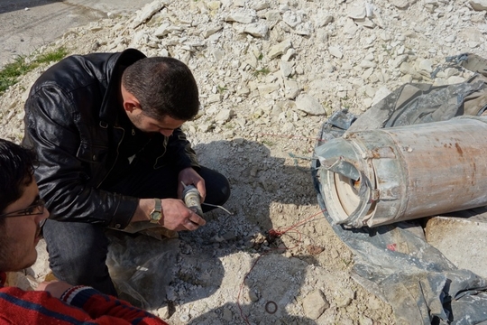 Jamil Ragib bestudeert het ontstekingsmechanisme van een gedeeltelijk ontmantelde BetAB-500 bom. (Foto: Damien Spleeters, Syrië, maart 2013)