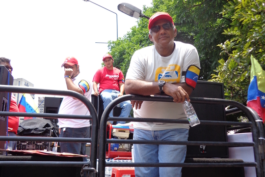Een Chavez-aanhanger op een campagne-auto langs de kant van de weg (Foto Wies Ubags)