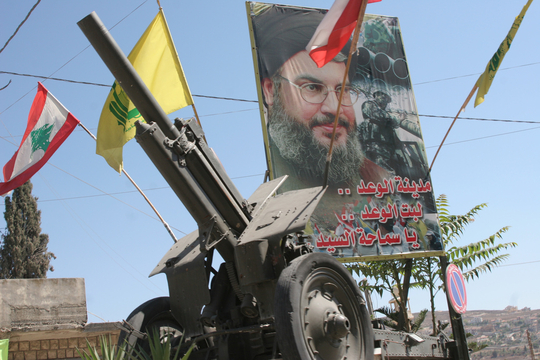 Hassan Nasrallah, een kanon en de vlaggen van Hezbollah en Libanon (foto cc: peaceworker46)