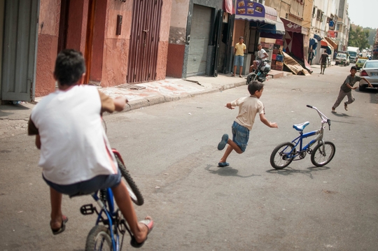 Deux enfants jouent à vélo dans la rue, Derb Marrakech. (Photo: Benoît Theunissen, 2012)