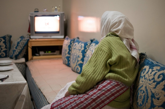 Une femme, de dos, tournée vers son écran de télévision, Derb Marrakech. (Photo: Benoît Theunissen, 2012)