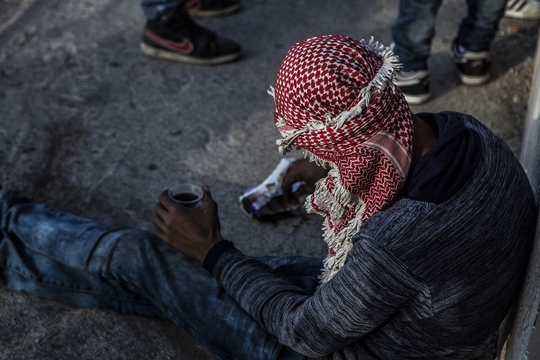 Een jonge Palestijn neemt een pauze tijdens de clashes om even wat te eten en te drinken. (Foto: Edmée van Rijn)