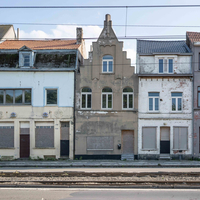 Verschillende leegstaande en vervallen woningen op een rij in Vlaanderen.